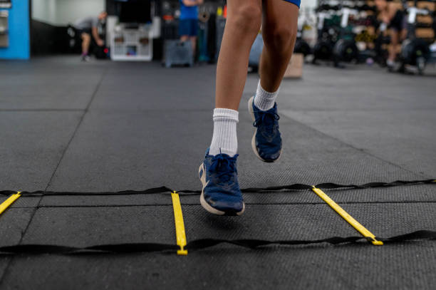 Athlete performing speed drills on agility ladder.